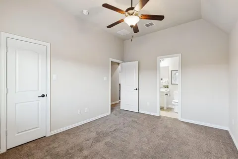 an empty room with closet and fan