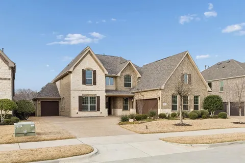a view of a house with a patio and a yard