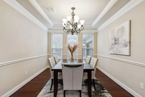 a view of a dining room with furniture wooden floor and chandelier