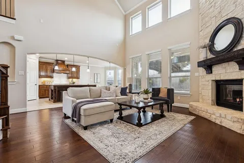 a living room with furniture a fireplace a rug and a large window