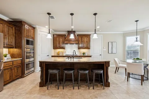 a dining table with chairs and kitchen view