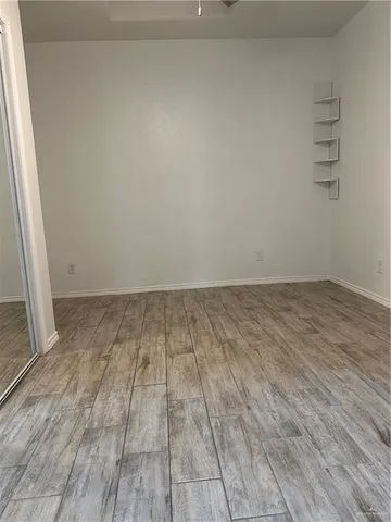 a view of an empty room with a chandelier fan and a window