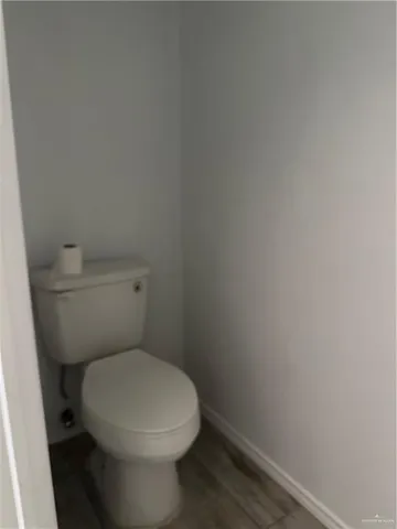 a white toilet sitting next to a white wall