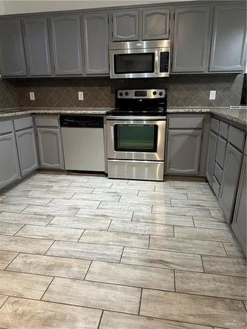 a kitchen with stainless steel appliances granite countertop a stove a sink and a microwave