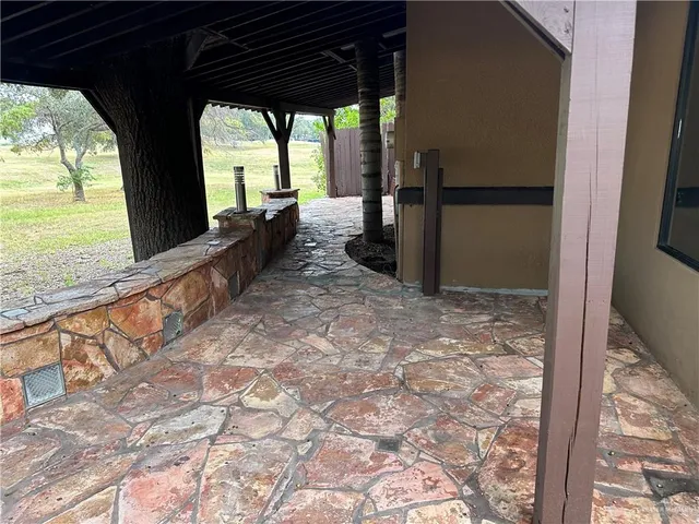 a view of a porch with furniture and floor to ceiling window