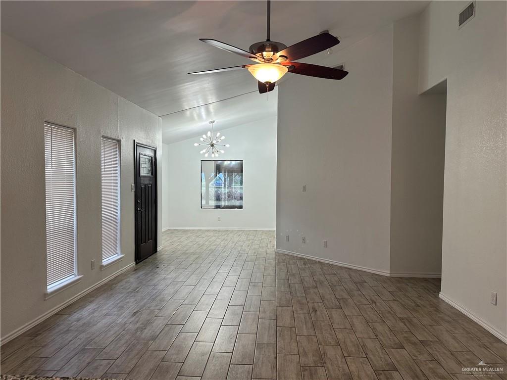 905 Colorado Court Mission, TX 78572 - Photo 9 of 42 an empty room with wooden floor chandelier fan and closet area