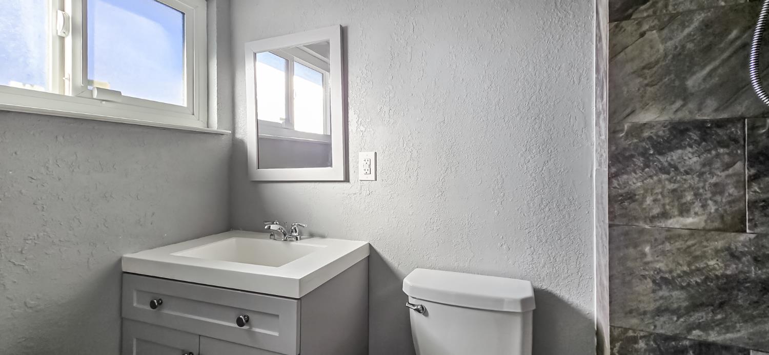 206 West 20th Street Tracy, CA 95376 - Photo 14 of 20 a bathroom with a sink toilet and window