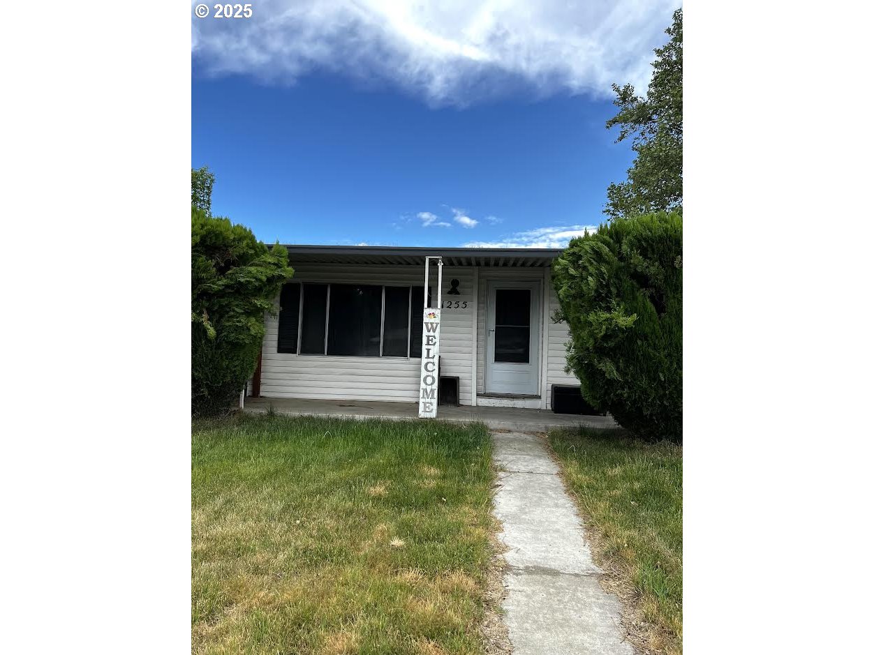 1255 Southwest Sandy Drive Hermiston, OR 97838 - Photo 2 of 16 a view of a house with a yard potted plants and a table