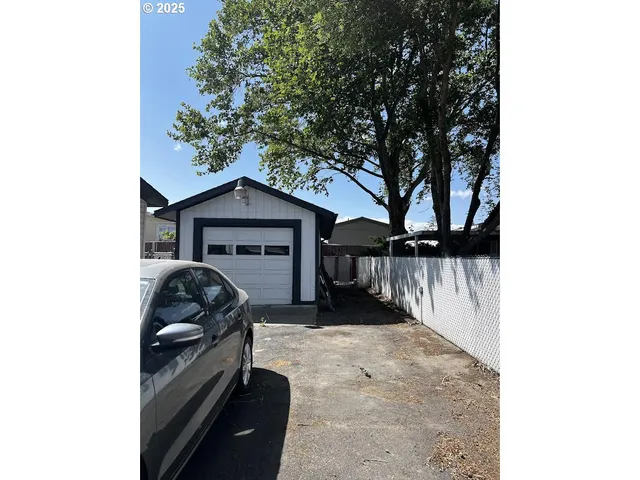 a car parked in front of a house with wooden fence