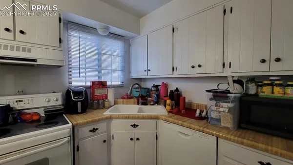 a kitchen with stainless steel appliances granite countertop a sink a stove and cabinets