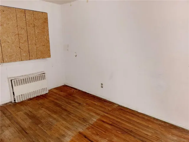 a view of a room with wooden floor and cabinet