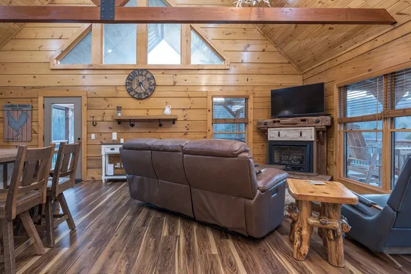a view of a hallway with wooden floor and a bathroom