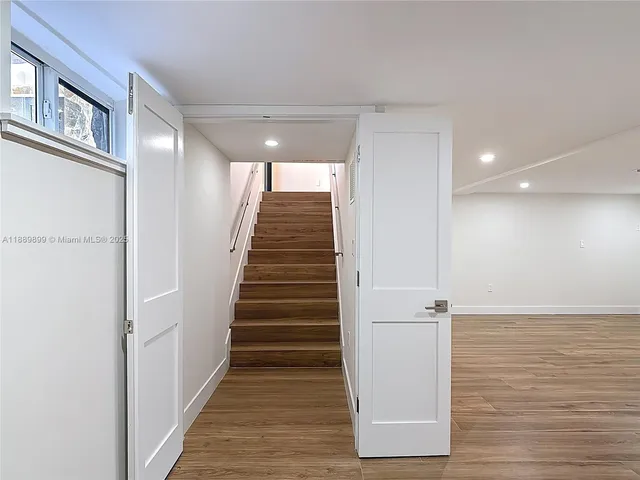 a view of a hallway with wooden floor and staircase
