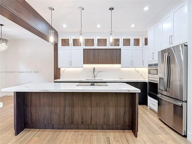 a kitchen with a sink a refrigerator and wooden cabinets