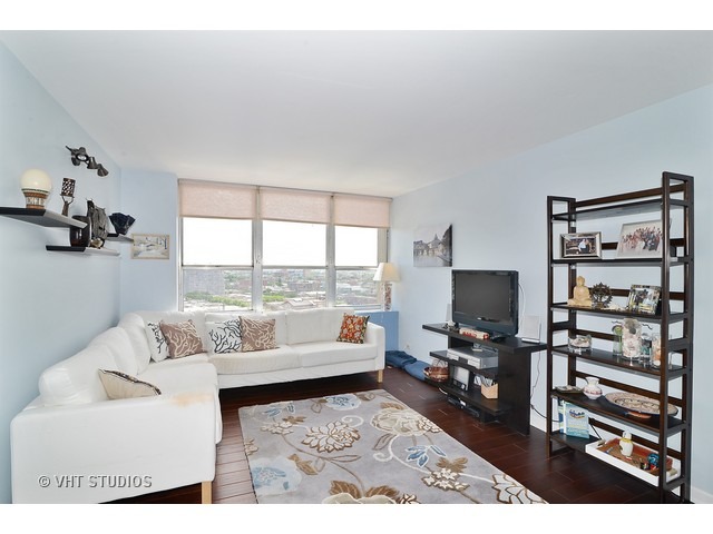 655 West Irving Park Road, Unit 1707 Chicago, IL 60613 - Photo 2 of 14 a living room with furniture and a flat screen tv