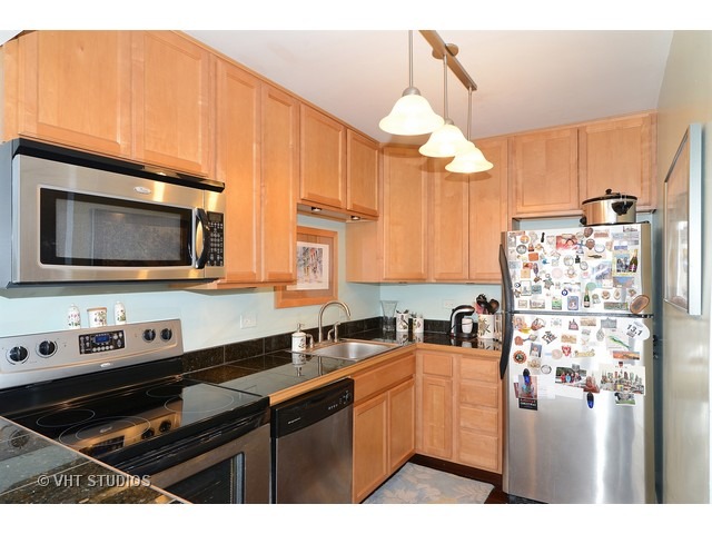 655 West Irving Park Road, Unit 1707 Chicago, IL 60613 - Photo 5 of 14 a kitchen with stainless steel appliances a stove a sink and a microwave