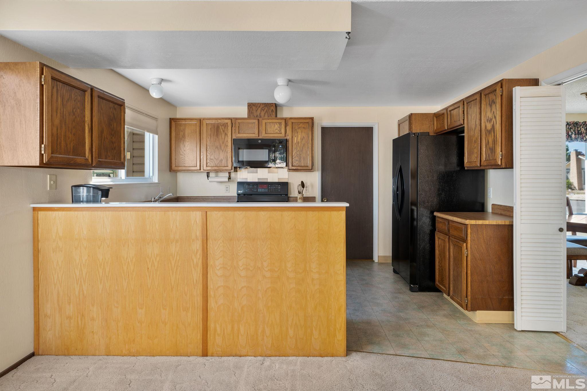 4315 Mendocino Lane Reno, NV 89502 - Photo 14 of 31 a kitchen with stainless steel appliances a refrigerator stove a sink and a microwave