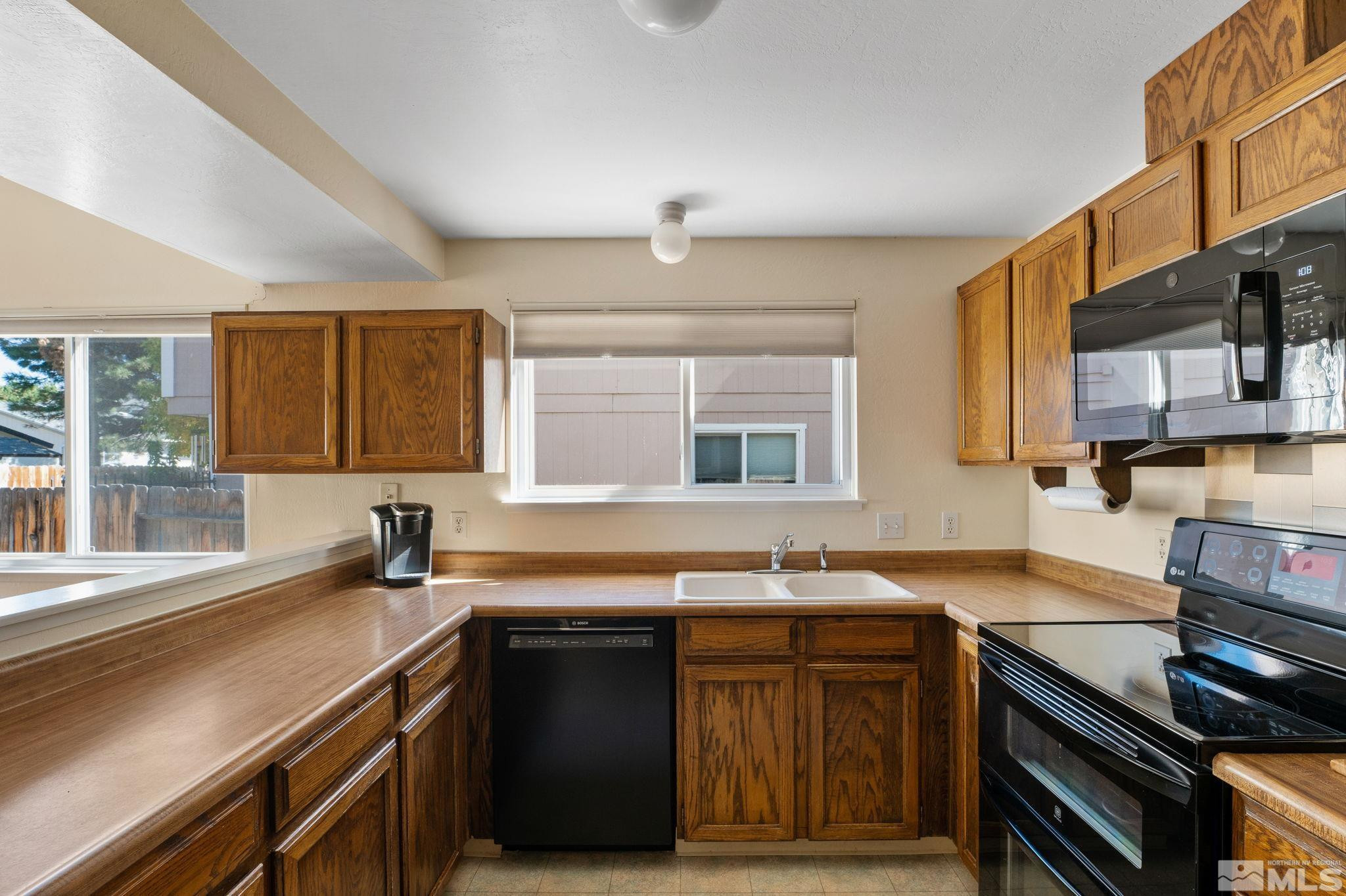 4315 Mendocino Lane Reno, NV 89502 - Photo 16 of 31 a kitchen with granite countertop a sink a stove and wooden cabinets