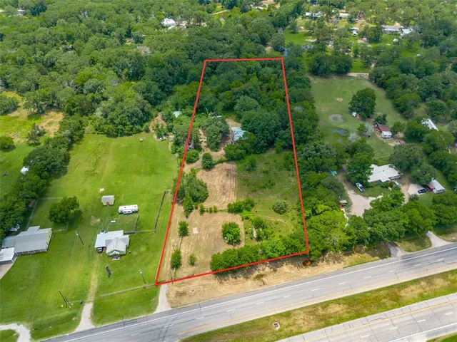 an aerial view of a residential houses with yard and swimming pool