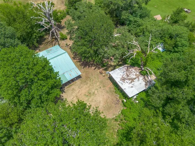 a view of a small house with potted plants and a table and chairs