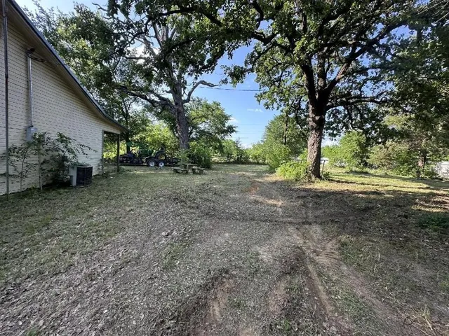 a backyard of a house with barbeque oven table and chairs