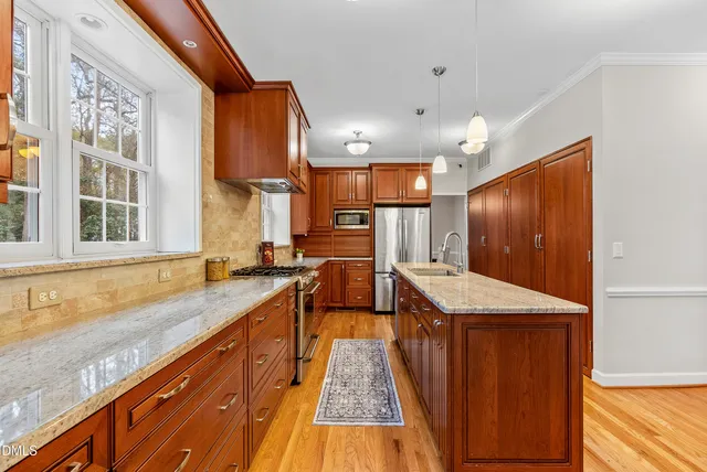 a dining room with furniture a chandelier and wooden floor