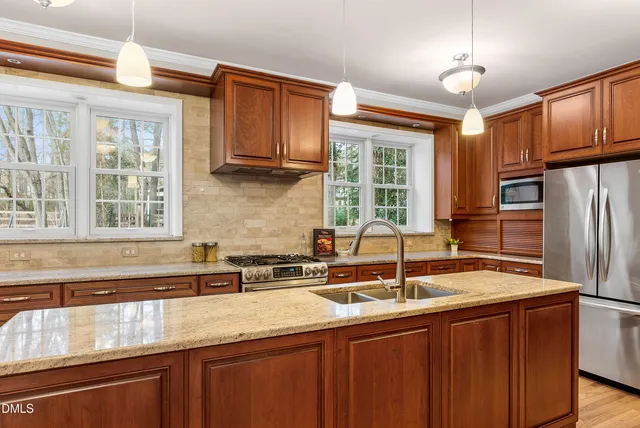 a kitchen with stainless steel appliances granite countertop a sink stove and cabinets