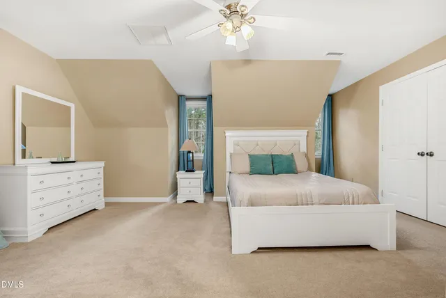 a spacious bedroom with a bed and a chandelier