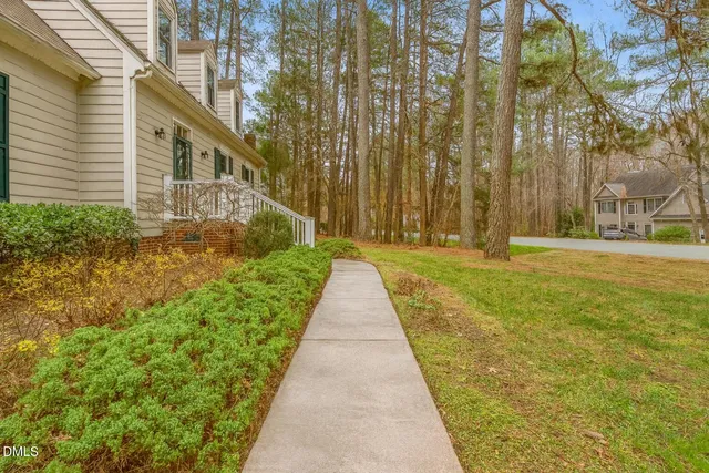 a front view of a house with a yard and trees