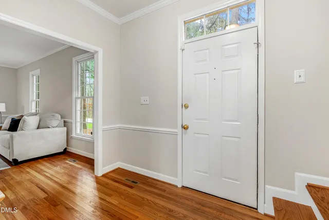 a view of entryway kitchen and hall with wooden floor