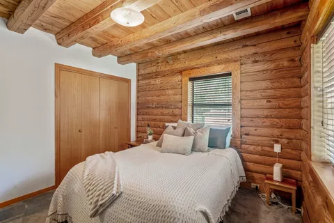a bedroom with a bed and wooden floor