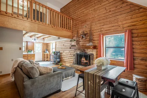 a living room with furniture a fireplace and a table