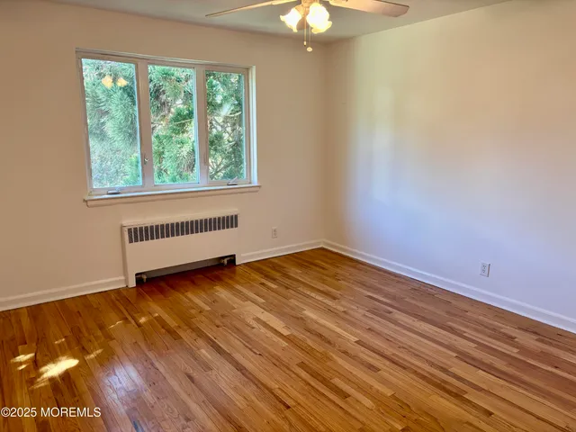 a view of a room with a window and a ceiling fan