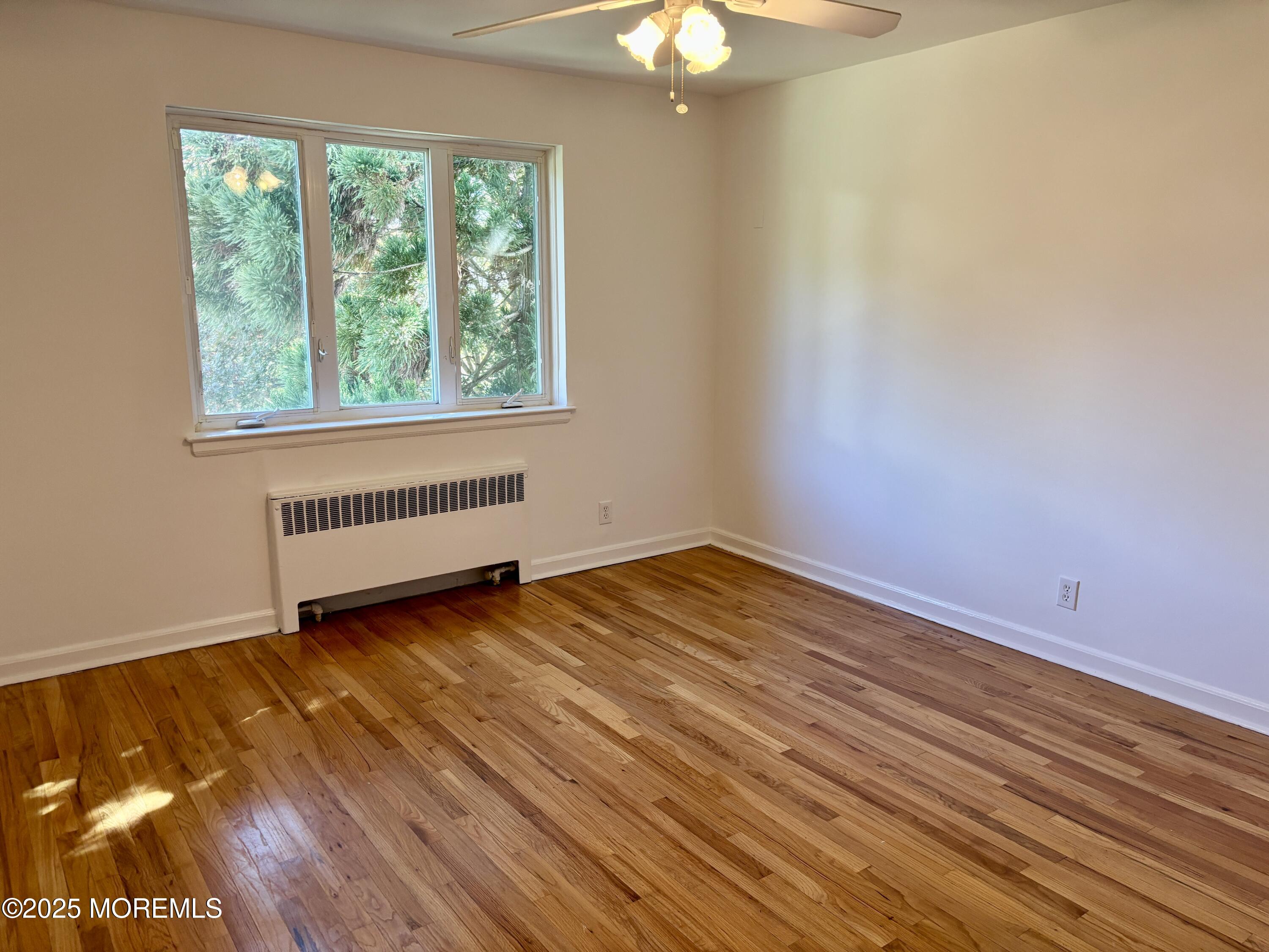 283 Spring Street, Unit 4C Red Bank, NJ 07701 - Photo 14 of 29 an empty room with wooden floor and windows