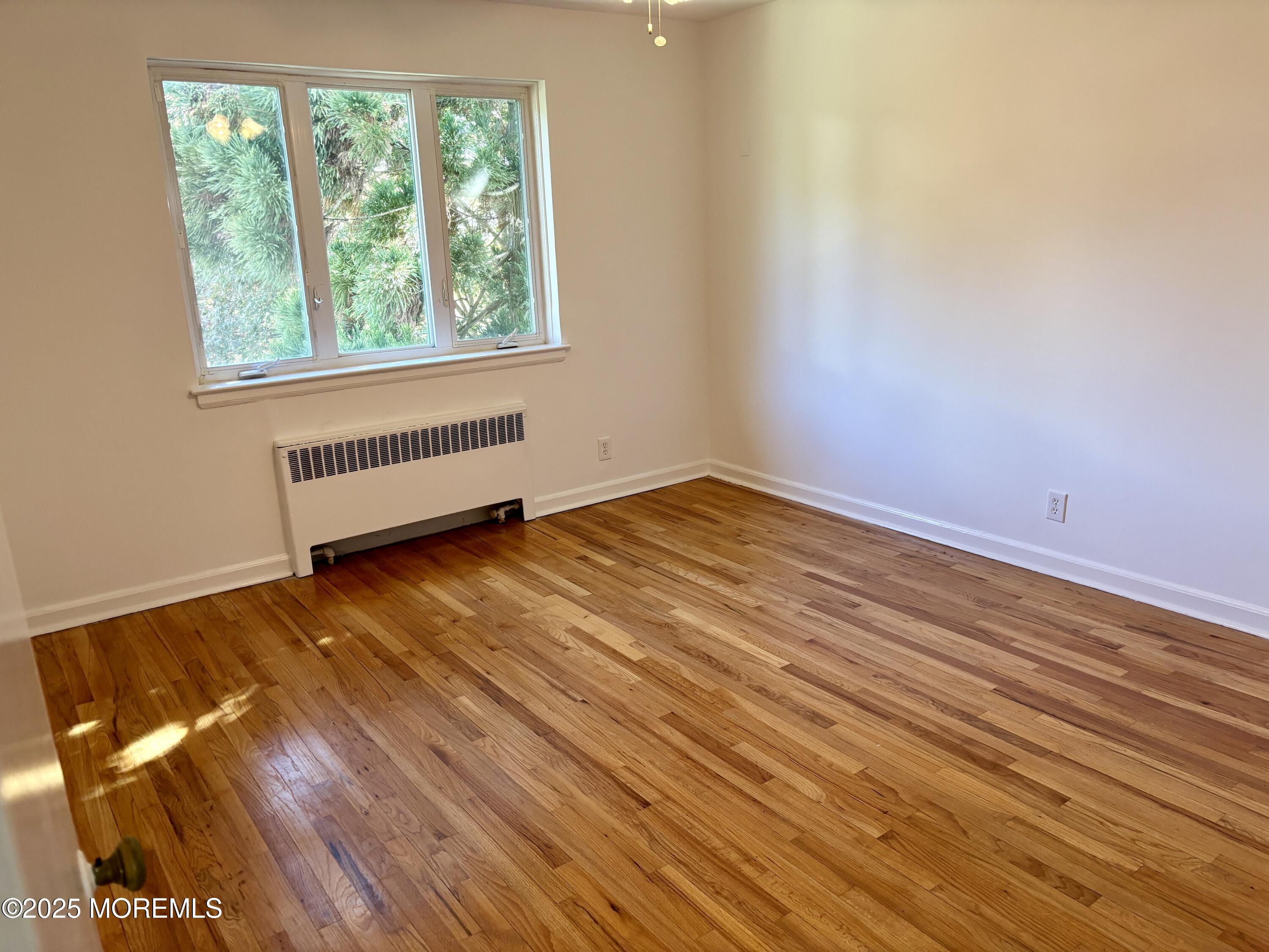 283 Spring Street, Unit 4C Red Bank, NJ 07701 - Photo 18 of 29 an empty room with wooden floor and windows