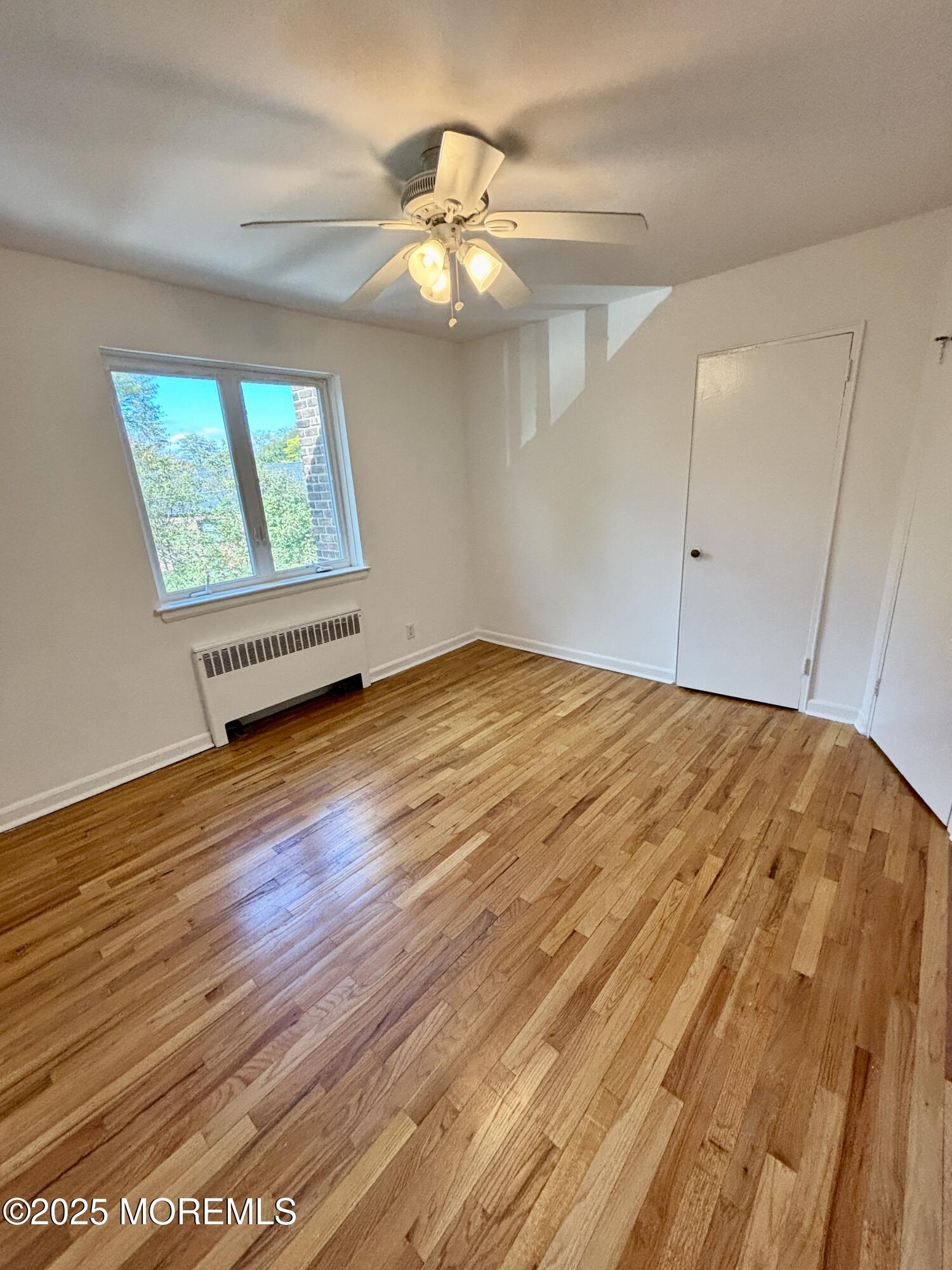 283 Spring Street, Unit 4C Red Bank, NJ 07701 - Photo 19 of 29 a view of an empty room with wooden floor and a window