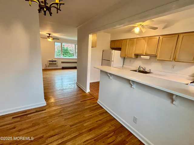 a kitchen with stainless steel appliances a stove a sink a refrigerator a counter space and cabinets