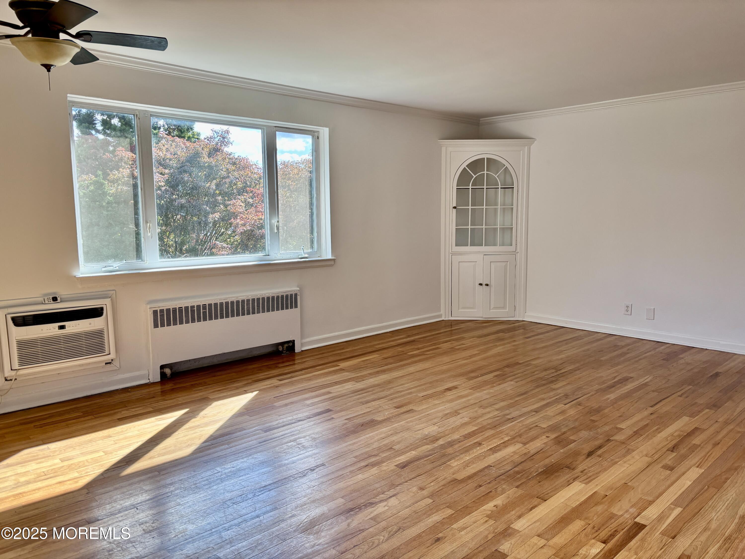 283 Spring Street, Unit 4C Red Bank, NJ 07701 - Photo 9 of 29 a view of an empty room with a window and wooden floor