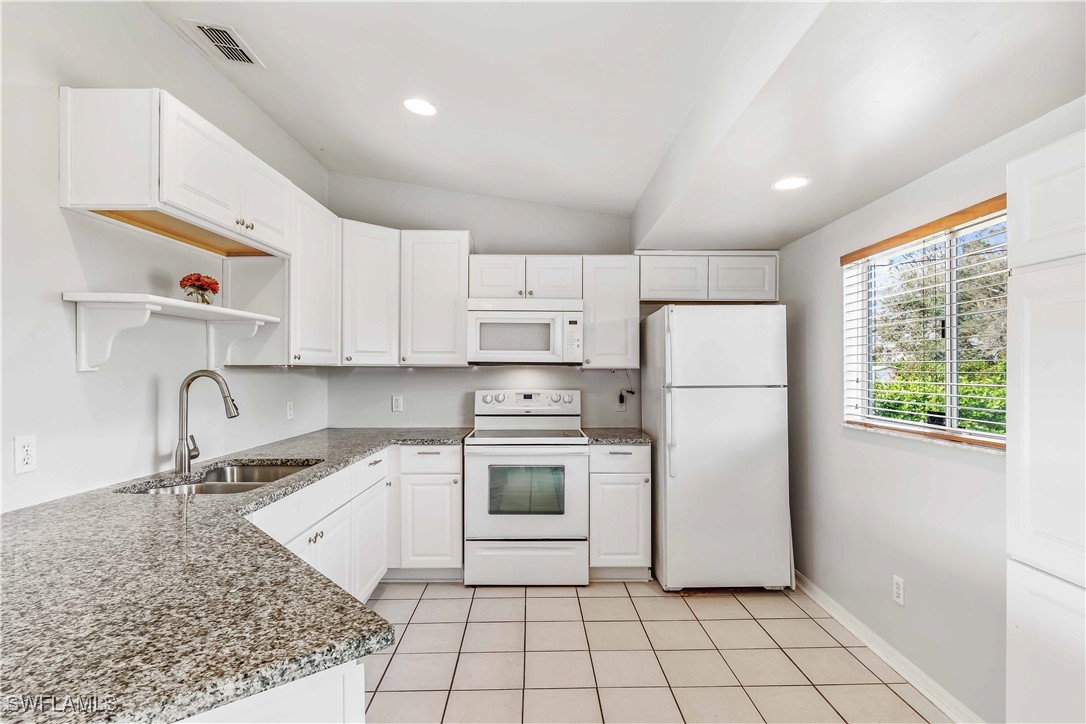 8457 Robin Road Fort Myers, FL 33967 - Photo 7 of 18 a kitchen with a sink a refrigerator and cabinets