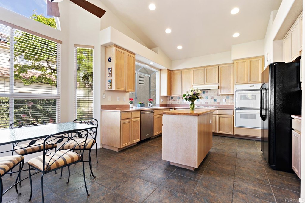 1667 Del Mar Road Oceanside, CA 92057 - Photo 12 of 51 a kitchen with a refrigerator a sink dishwasher with a dining table and chairs