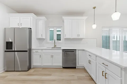 a kitchen with white cabinets and stainless steel appliances