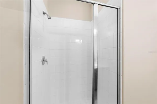 a bathroom with a glass shower door and a bathroom