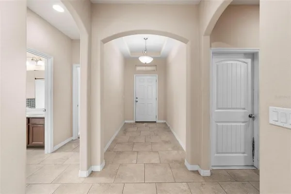 a view of a hallway with wooden floor and a bathroom