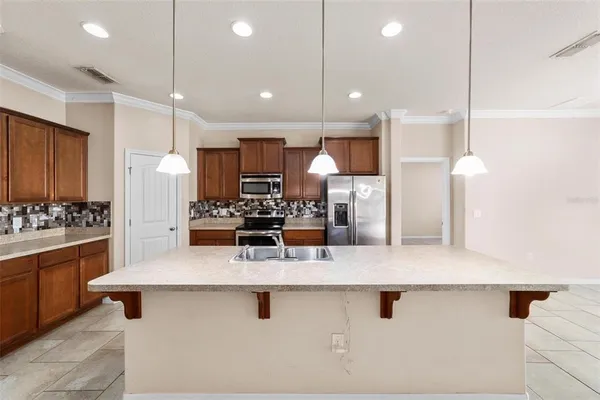 a kitchen with stainless steel appliances granite countertop a sink refrigerator and cabinets