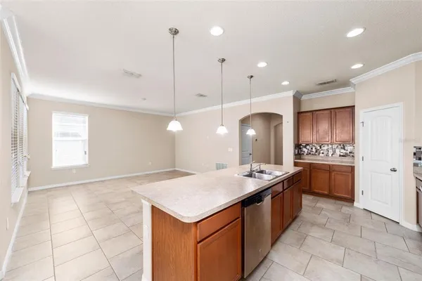 a kitchen with a stove a sink a counter top space and cabinets
