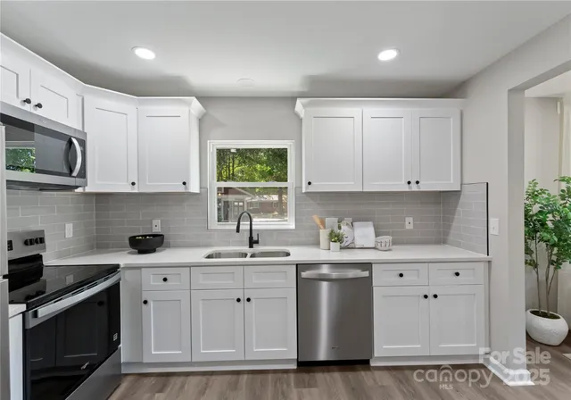 a kitchen with white cabinets stainless steel appliances and sink