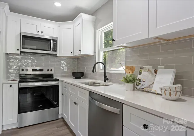 a kitchen with sink a microwave and cabinets
