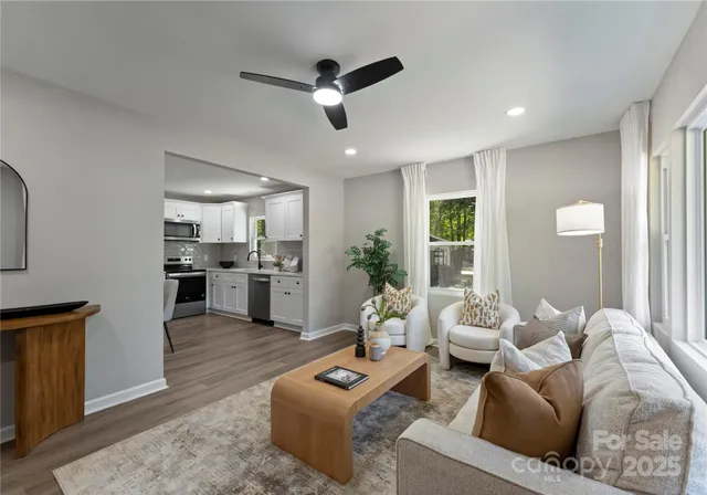 a living room with furniture and a view of kitchen