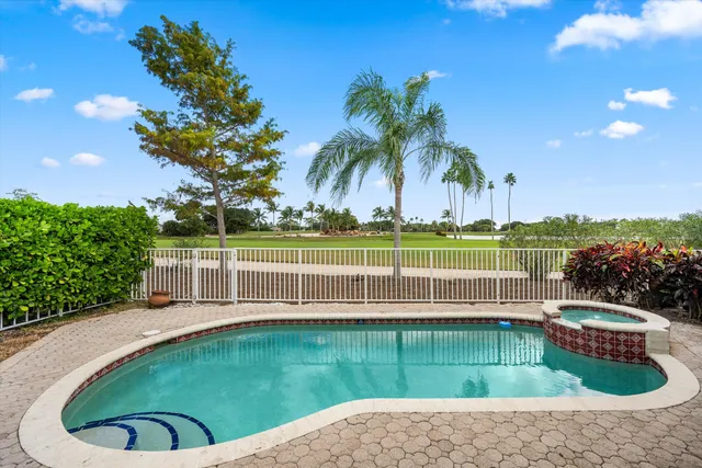 a view of a swimming pool with a garden and seating area