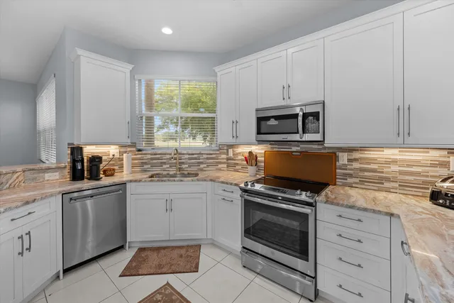 a kitchen with cabinets appliances and a window